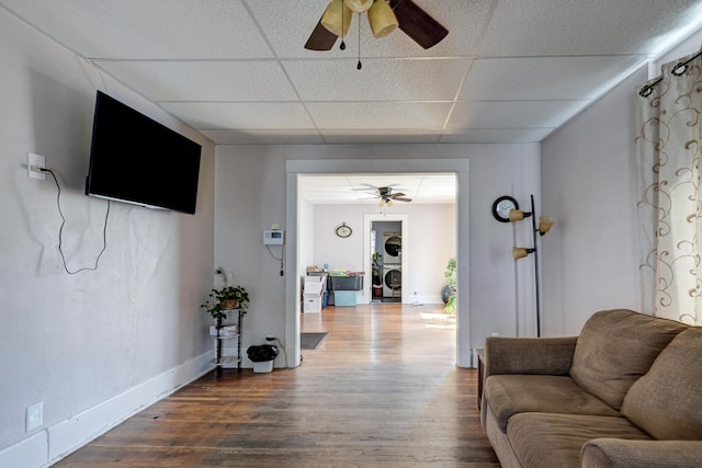 living area with ceiling fan, washer / clothes dryer, a drop ceiling, and wood finished floors