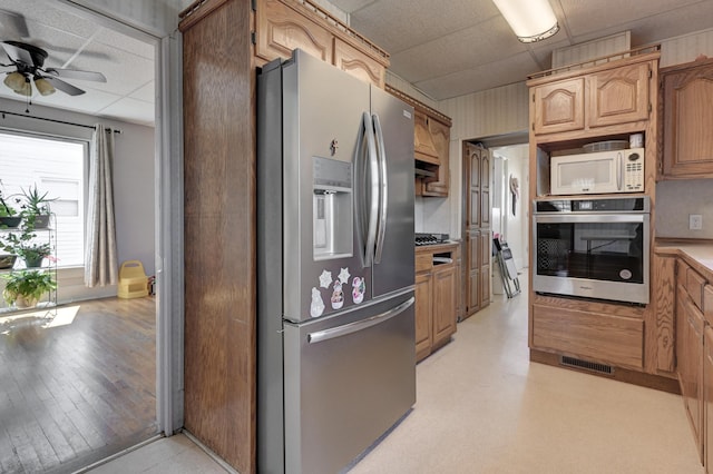 kitchen with ceiling fan, visible vents, stainless steel appliances, and a drop ceiling