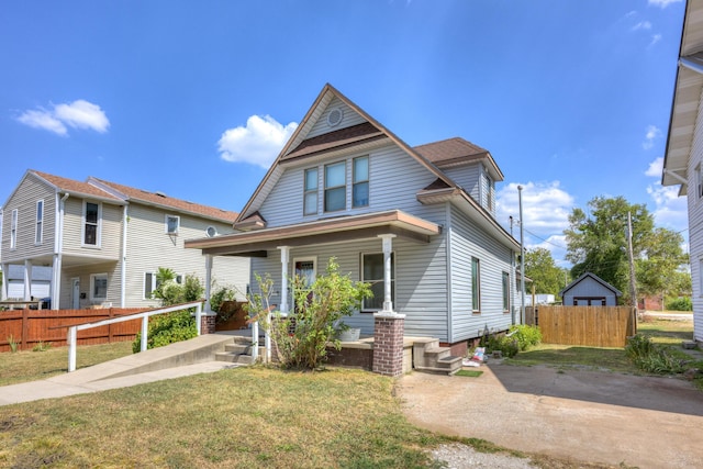 view of front facade featuring fence, a porch, and a front yard