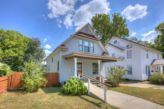 view of front of home featuring a porch, a front yard, and fence