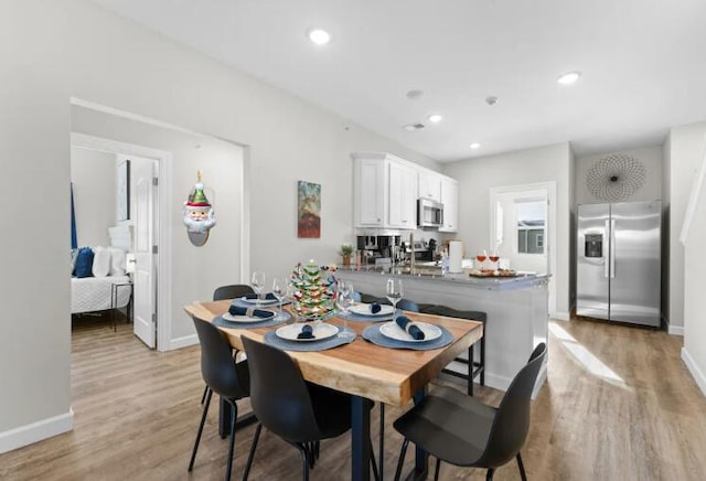 dining space with recessed lighting, baseboards, and light wood finished floors