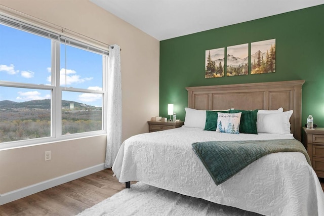 bedroom with baseboards and wood finished floors