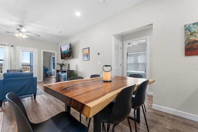 dining room with a ceiling fan, baseboards, and wood finished floors