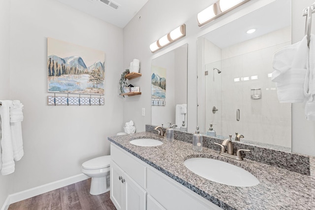 bathroom featuring wood finished floors, a stall shower, a sink, and toilet