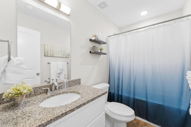 bathroom featuring visible vents, toilet, vanity, wood finished floors, and a shower with curtain