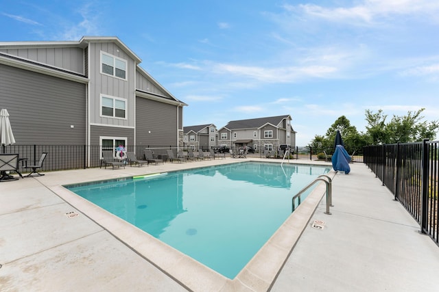 pool featuring a patio area, fence, and a residential view