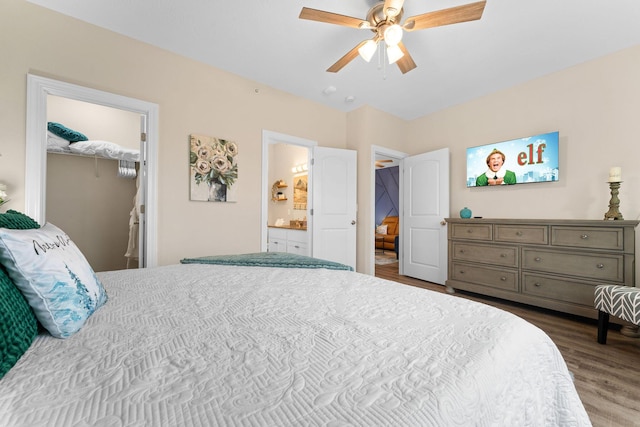 bedroom featuring a ceiling fan, wood finished floors, ensuite bathroom, a spacious closet, and a closet