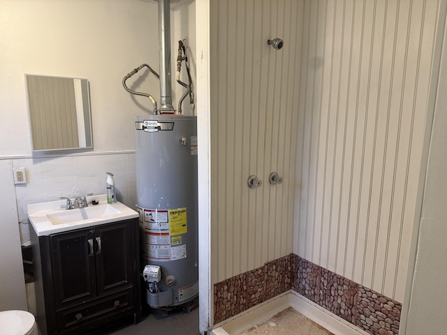 bathroom featuring water heater, tile walls, and vanity