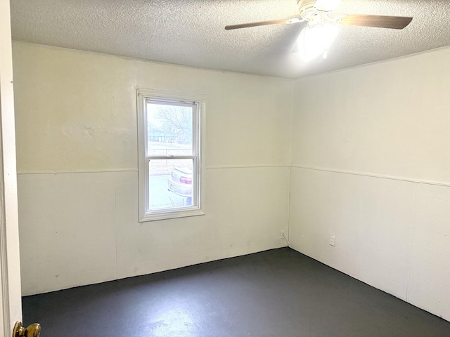 empty room with a ceiling fan, concrete floors, and a textured ceiling