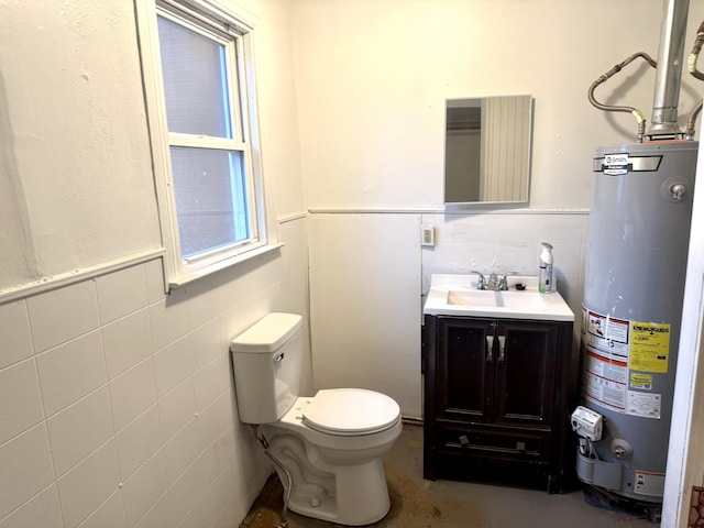 half bathroom with a wainscoted wall, tile walls, water heater, toilet, and vanity