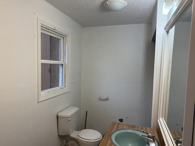 bathroom featuring a textured ceiling, vanity, and toilet