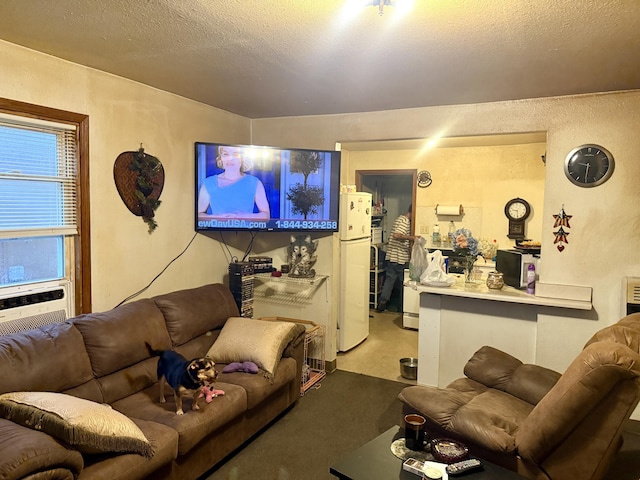 living area featuring cooling unit, a textured wall, and a textured ceiling