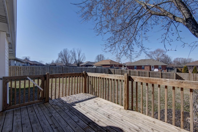 wooden terrace featuring a fenced backyard and a residential view