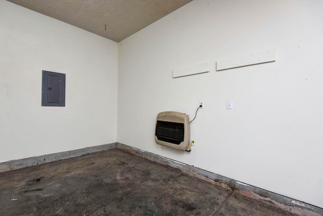 laundry area featuring heating unit, electric panel, and a textured ceiling