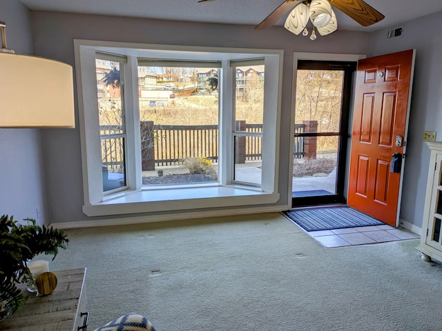 doorway to outside with a wealth of natural light, carpet flooring, visible vents, and baseboards