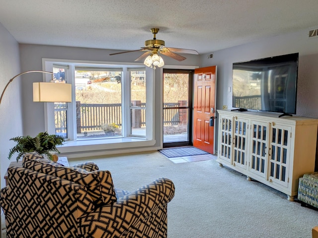 living room featuring carpet flooring, plenty of natural light, and a textured ceiling