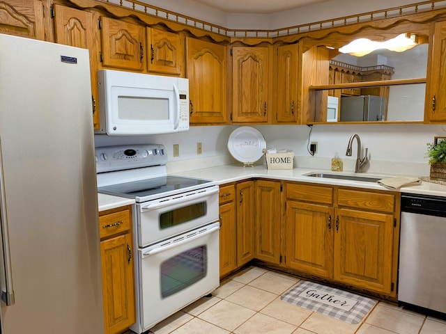 kitchen featuring stainless steel appliances, brown cabinetry, a sink, and light countertops