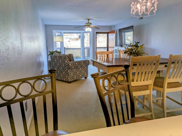 dining space with a textured wall, carpet floors, a textured ceiling, and a chandelier