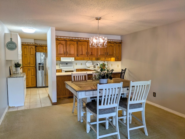 dining room with light carpet, light tile patterned floors, baseboards, an inviting chandelier, and a textured ceiling