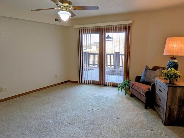 living area featuring light colored carpet, visible vents, ceiling fan, and baseboards