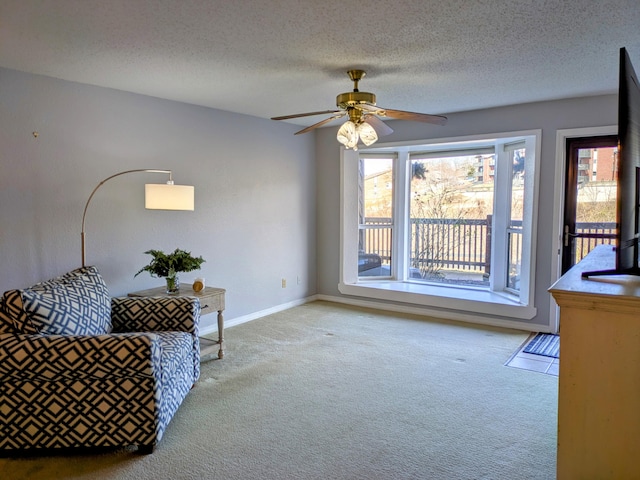 living area featuring a textured ceiling, carpet floors, and baseboards