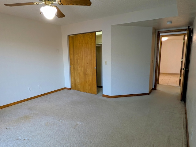 unfurnished bedroom with carpet, a textured ceiling, and baseboards