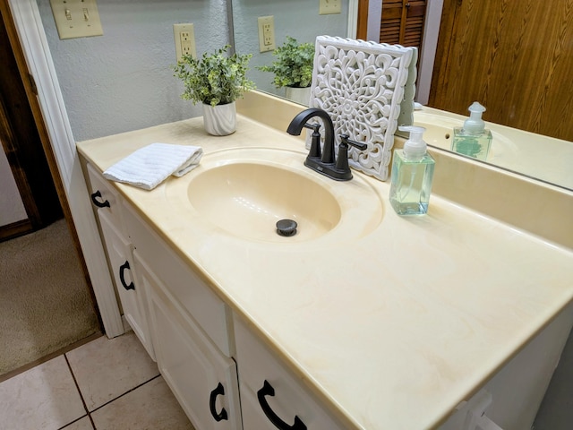 bathroom with a textured wall, vanity, and tile patterned floors