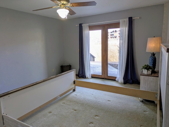 unfurnished bedroom with carpet floors, access to exterior, and a ceiling fan