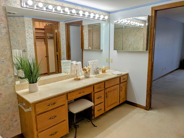 bathroom featuring wallpapered walls, vanity, and baseboards