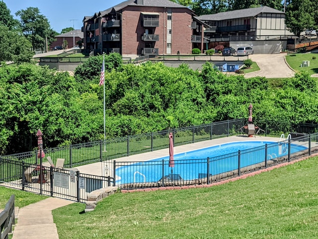 community pool featuring a yard and fence