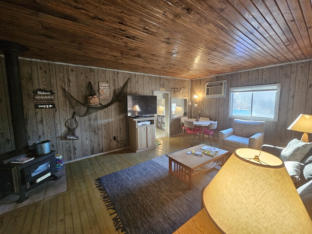 living room featuring a wood stove, wooden ceiling, a wall mounted AC, and hardwood / wood-style flooring