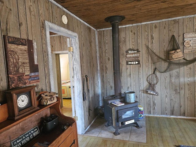 room details with a wood stove, wooden ceiling, wooden walls, and wood finished floors