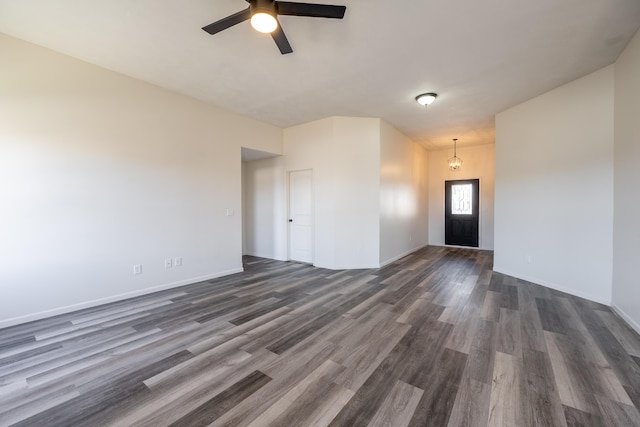 unfurnished room featuring baseboards, a ceiling fan, and dark wood-type flooring