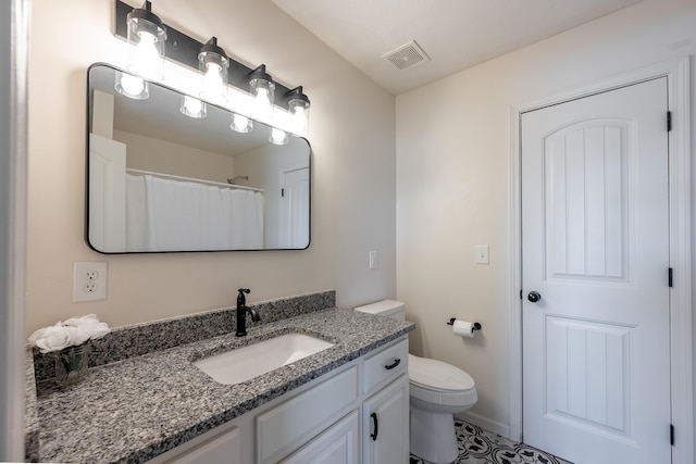 bathroom featuring toilet, vanity, and visible vents