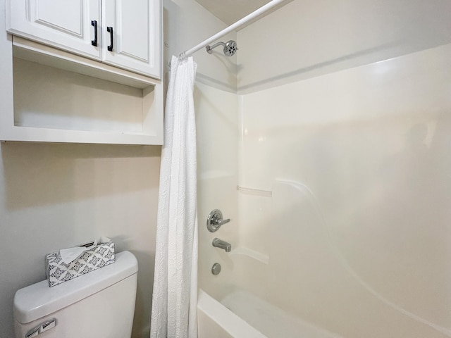 bathroom with shower / bath combination with curtain and toilet