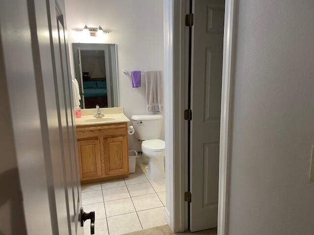 bathroom featuring toilet, tile patterned flooring, and vanity