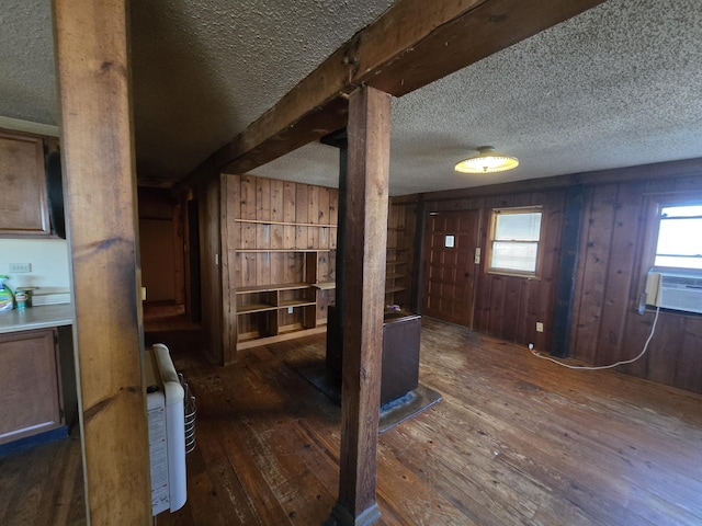 interior space with cooling unit, wood-type flooring, wood walls, and a textured ceiling