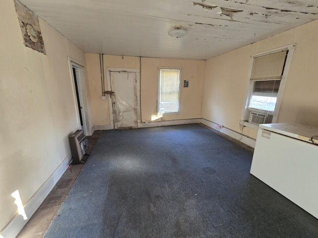 empty room featuring baseboards and cooling unit