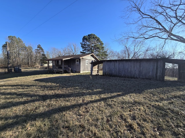 view of property exterior featuring an outbuilding, a lawn, and an outdoor structure