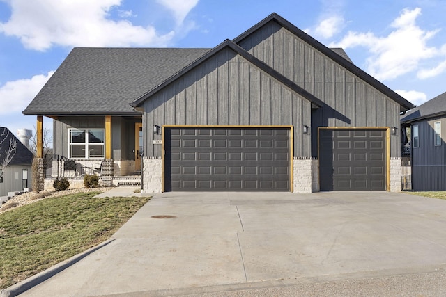 modern inspired farmhouse with an attached garage, stone siding, driveway, and a shingled roof