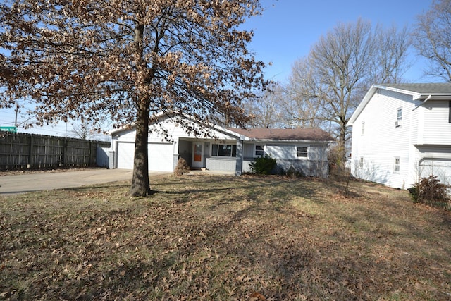 view of front of home featuring driveway, an attached garage, fence, and a front yard