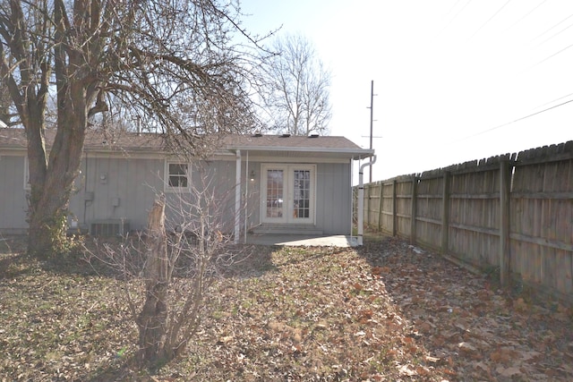 rear view of property featuring french doors, central AC unit, and fence