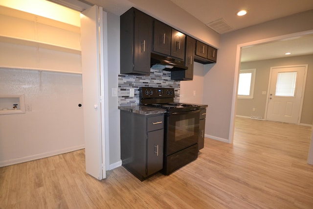 kitchen featuring tasteful backsplash, dark countertops, black range with electric stovetop, light wood-style flooring, and under cabinet range hood