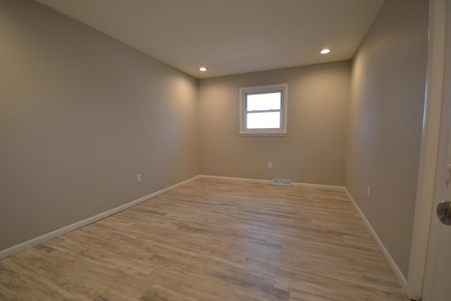 spare room with light wood finished floors, recessed lighting, visible vents, and baseboards