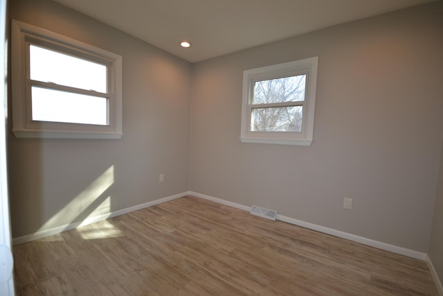 unfurnished room featuring recessed lighting, visible vents, baseboards, and wood finished floors