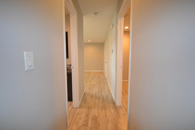 hall with light wood-style floors, recessed lighting, and baseboards