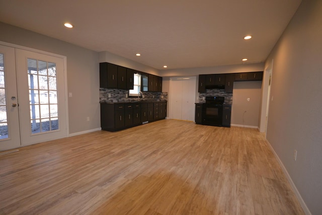 unfurnished living room featuring a wealth of natural light, french doors, and light wood finished floors