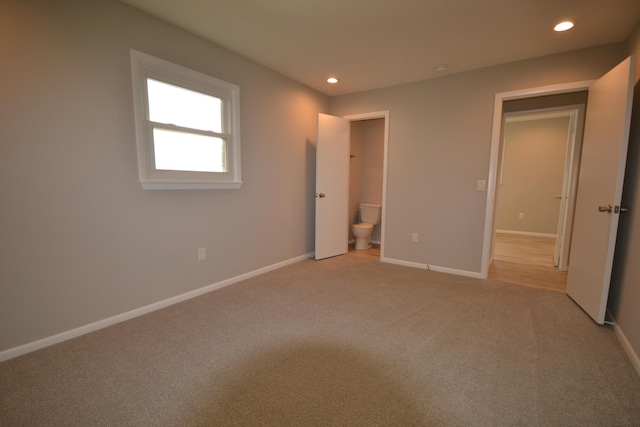 unfurnished bedroom featuring light carpet, baseboards, connected bathroom, and recessed lighting