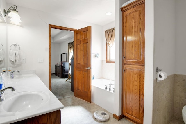 bathroom with a garden tub, a sink, toilet, and double vanity