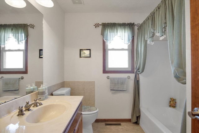 full bath featuring toilet, a wealth of natural light, vanity, and visible vents